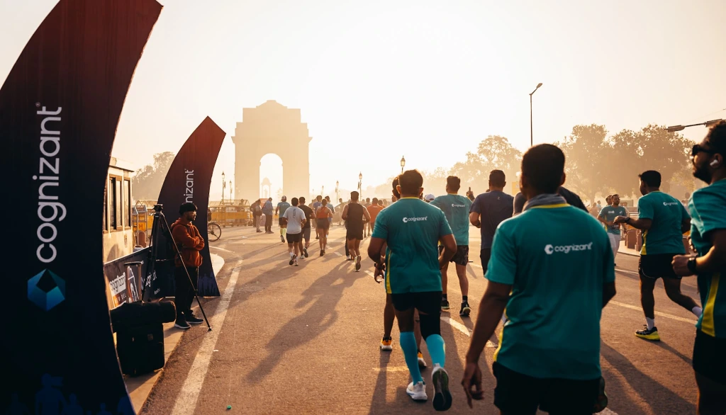 Cognizant New Delhi Marathon runners on a Delhi road with India Gate in the background